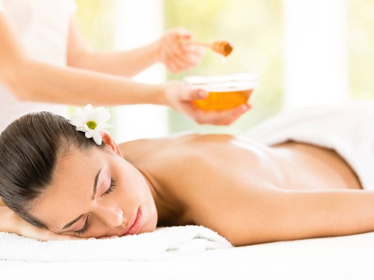 Kobieta w czasie masażu. Obrazek w artykule Masaż miodem. Co to jest i jak działa nietypowy masaż relaksacyjny?