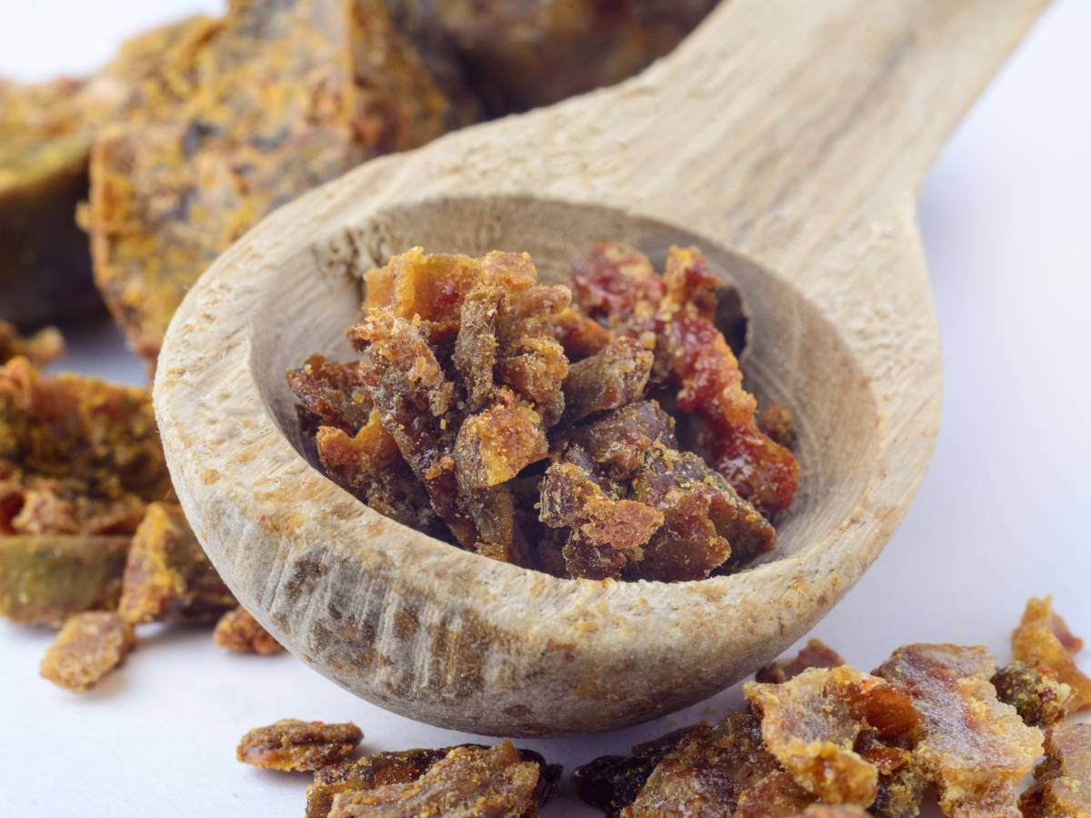 Drewniana łyżka z fragmentami plastra. Obrazek w artykule Pierzga a rak. Poznaj potencjalne korzyści w walce z nowotworami